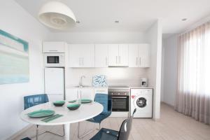 biała kuchnia z białym stołem i krzesłami w obiekcie Blancazul Ocean View w mieście Playa Blanca +7 zdjęć