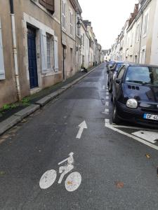 uma placa de bicicleta numa rua ao lado de um carro em L'ATELIER Calme et Cosy à 2 pas de la cathédrale em Orléans