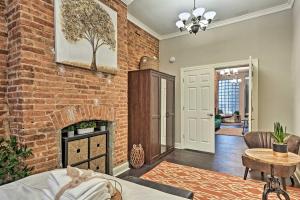 a living room with a brick wall and a fireplace at Chic Baltimore Apartment 2 Mi to Downtown! in Baltimore