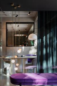 Zimmer mit lila Stühlen und einem Tisch mit Lampen in der Unterkunft EmiLu Design Hotel in Stuttgart
