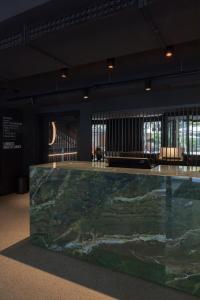 a large green marble counter in a room with windows at EmiLu Design Hotel in Stuttgart