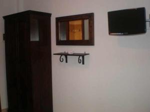 a room with a tv and a table on a wall at Hotel Sarandos in Ammouliani +10 photos