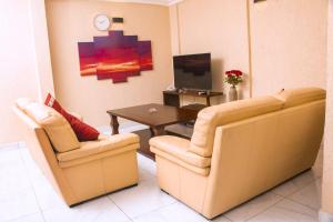 uma sala de estar com duas cadeiras e uma mesa em Residence Le Bonheur - Serviced apartment by Douala Airport/Mall em Douala