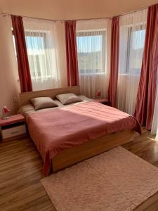 um quarto com uma cama grande e cortinas vermelhas em УЗВАР em Bobrka