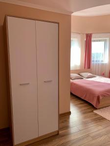 a bedroom with a large white cabinet next to a bed at УЗВАР in Bobrka