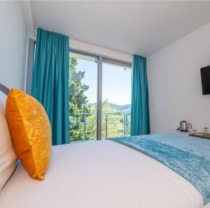 a bedroom with a large bed with a large window at Passerella Apartments in Bar
