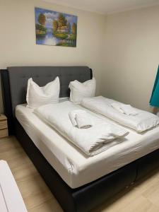 a bed with white sheets and pillows on it at Apartments Am Bahnhof in Siegen
