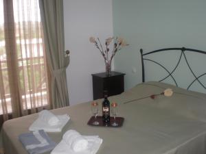 a room with a table with a bottle of wine and towels at Hotel Sarandos in Ammouliani
