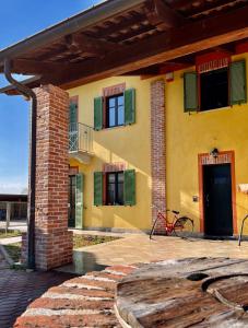 a yellow building with green windows and a door at La Casa delle Favole in Fossano