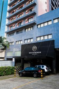 dos coches estacionados frente a un edificio en Master Grande Hotel - Centro Histórico, en Porto Alegre