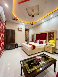 Horizon Hotel في لاهور: غرفة نوم بسرير وطاولة في غرفة