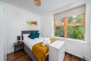 1 dormitorio con cama y ventana en Stylish Central Watford 2 Bedroom and Sofa Bed Apartment with Free Parking, en Watford