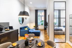 a living room with a table and a blue couch at Nola Apartments in Krakow