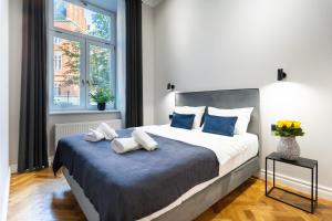 a bedroom with a large bed with two towels on it at Nola Apartments in Krakow