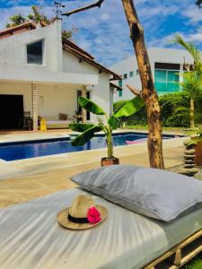 a hat sitting on a bed next to a pool at With Us Hotel by Coccoloba in Flandes