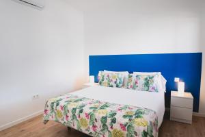 een slaapkamer met een groot wit bed met een blauw hoofdeinde bij Blancazul Tegala in Playa Blanca