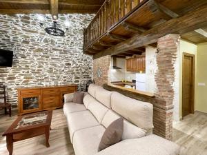 - un salon avec un canapé et un mur en briques dans l'établissement Recuerdos de Monfragüe, à Malpartida de Plasencia