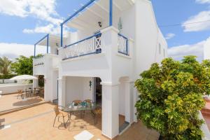 a white house with a balcony and a patio at Apartamento 6 Bajo in Arrieta