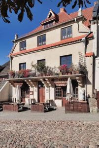 a large white building with a balcony with flowers at Apartamenty Dom Kifnera in Kazimierz Dolny