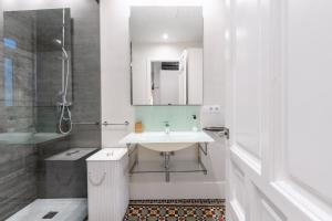 y baño blanco con lavabo y ducha. en AoA Green Gardens Suites, en Sevilla