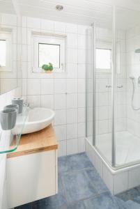 a white bathroom with a sink and a shower at Fewo Grete in Norderney