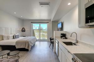 a bedroom with a bed and a kitchen with a sink at Lively Beach in Corpus Christi