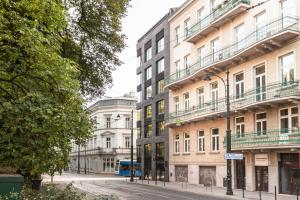 a city street with tall buildings and a bus at Nola Apartments in Krakow
