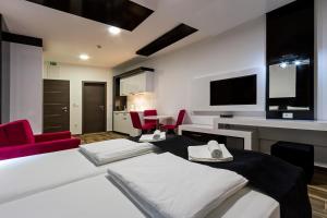 a room with a bed and chairs and a tv at Velestovo View Apartments in Ohrid