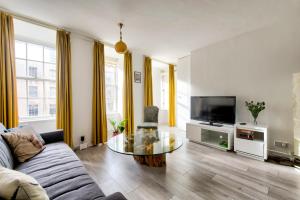a living room with a couch and a glass table at GuestReady - Bright & Airy 1BR Flat in the heart of Edinburgh in Edinburgh