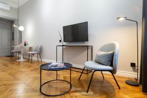 a living room with chairs and a tv and a table at Nola Apartments in Krakow