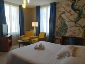アンボワーズにあるロジ ホテル レストラン ラ ブルシュのベッド付きの客室で、壁には絵画が飾られています。