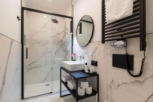 a bathroom with a shower and a sink and a mirror at Nola Apartments in Krakow +34 photos