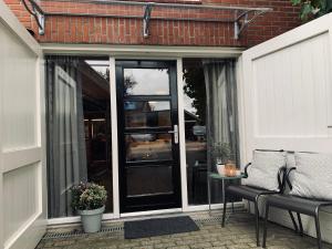eine abgeschirmte Veranda mit einer Glastür und einem Stuhl in der Unterkunft Bed & Breakfast "aan de banis" in Rijssen
