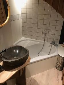 a bathroom with a bath tub with a sink at Bois & Repos in Malmedy