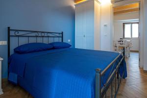a blue bedroom with a large bed with blue sheets at IL MASCHERONE in Sepino