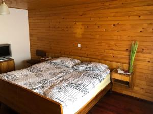 a bedroom with a bed with a wooden wall at Old Traditional House in Visoko