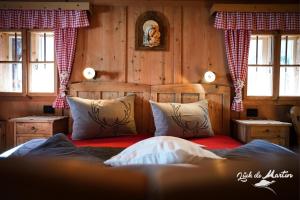 a bedroom with a bed in a room with wooden walls at Lüch de Martin in La Valle