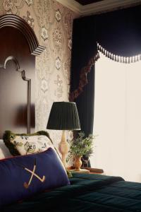 a bedroom with a bed and a lamp and a window at Rusacks St Andrews in St. Andrews