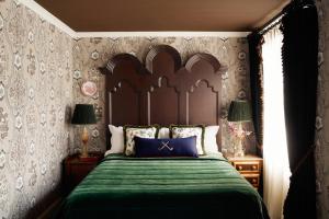a bedroom with a large bed with a green bedspread at Rusacks St Andrews in St. Andrews