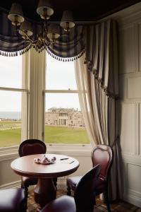 a dining room with a table and chairs and a window at Rusacks St Andrews in St. Andrews