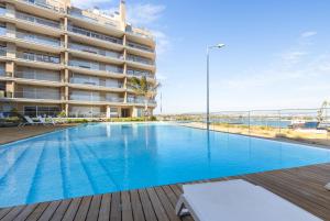 a large swimming pool in front of a building at One River Seixal in Seixal