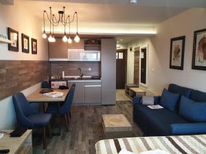 a living room with a blue couch and a kitchen at Milmari Premier40 in Kopaonik