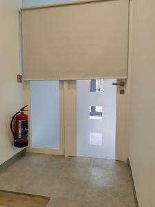 a room with a white door and a fire extinguisher at Vakantiehuis H&A 4 sterren in Ieper