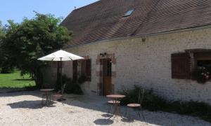 - un bâtiment avec une table, des chaises et un parasol dans l'établissement Chambres d'Hôtes L’Échappée Belle, à Saint-Brisson-sur-Loire