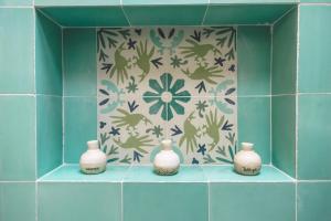 four white vases sitting on a shelf in a bathroom at TreeHouse Boutique Hotel, an adults only boutique hotel in Mérida