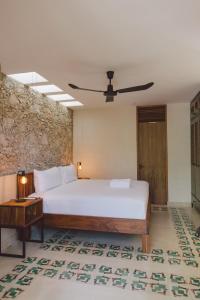 Un dormitorio con una gran cama blanca y una mesa en TreeHouse Boutique Hotel, an adults only boutique hotel en Mérida