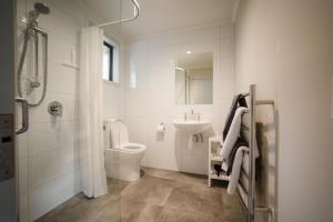 La salle de bains blanche est pourvue de toilettes et d'un lavabo. dans l'établissement Invercargill Holiday Park & Motels, à Invercargill