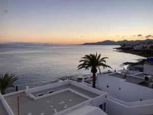 a view of the ocean at sunset from a building at Casa Tito in Puerto del Carmen