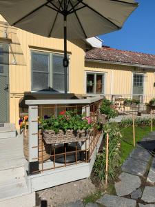a patio with an umbrella and some plants in it at Två Små Svin BnB in Trosa