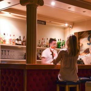 a woman sitting at a bar drinking a glass of wine at Seaside Hotel in Loutraki +24 photos